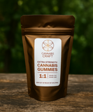 Brown package of Cannabis Craft gummies on a wooden surface with a blurred green background
