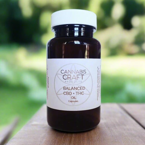 A bottle of BALANCED CBD + THC capsules with a white label on it, placed on a white background.